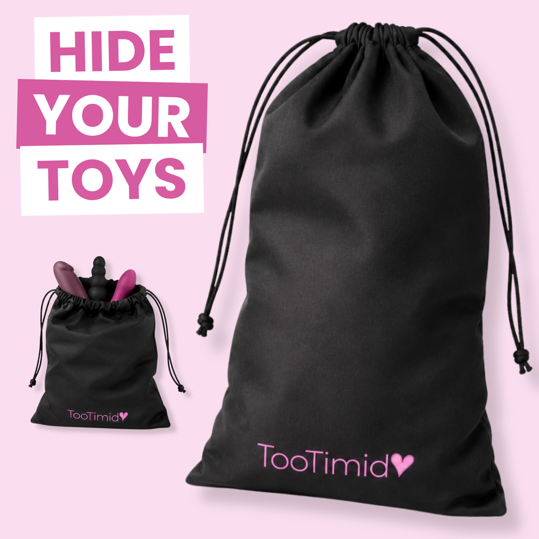 A black drawstring pouch shown on a light pink background, with the TooTimid logo printed in pink near the bottom. A large text overlay reads 'HIDE YOUR TOYS,' and a smaller inset shows the pouch closed with a toy partially tucked inside.