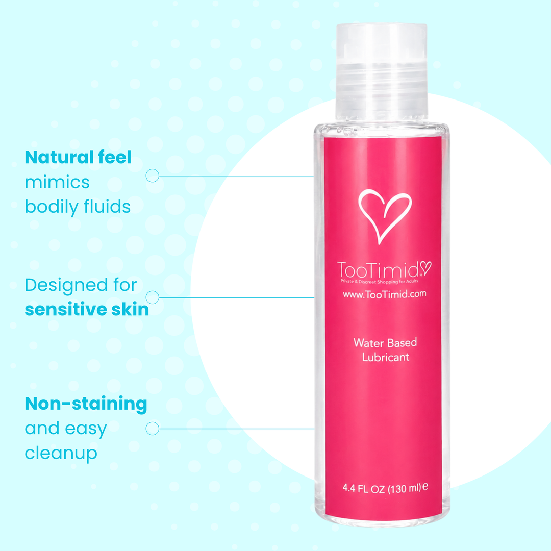 A bottle of TooTimid Water Based Lubricant with a bright pink label, shown on a light blue background with white circular graphic elements and marketing text pointing to the product features.