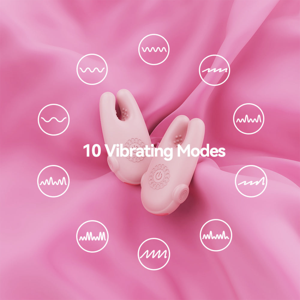 A pink personal massager with two curved silicone arms lies on a pink satin fabric background. White text in the center reads '10 Vibrating Modes,' and white waveform icons are scattered around the product to illustrate vibration modes.