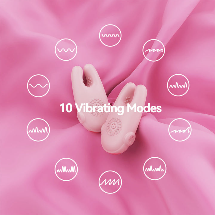 A pink personal massager with two curved silicone arms lies on a pink satin fabric background. White text in the center reads '10 Vibrating Modes,' and white waveform icons are scattered around the product to illustrate vibration modes.