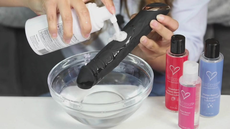 Cleaning vibrating dildo with TooTimid foaming toy cleaner and water.
