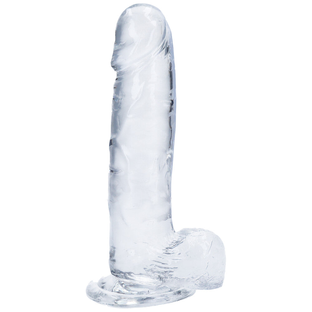 Side view of large clear realistic suction cup dildo with balls.