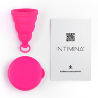 Image showing all that is included with the product. The menstrual cup, the case, and the user guide.