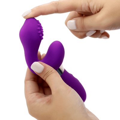 Image of the vibrator held in hand, from the side, and with a finger on the tip to show its flexibility.