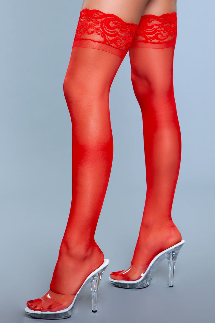 Model facing left wearing red spandex sheer thigh highs with silicone lace top