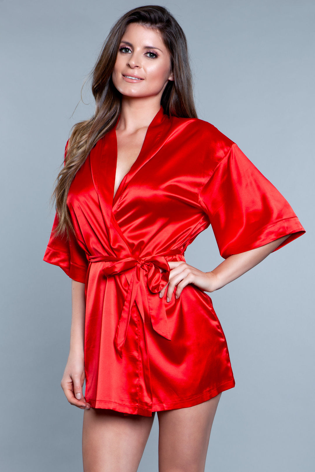 Model facing forward wearing red satin robe with side pockets. 3/4 sleeves and satin sash front tie