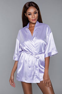 Model facing forward wearing lavender satin robe with side pockets. 3/4 sleeves and satin sash front tie