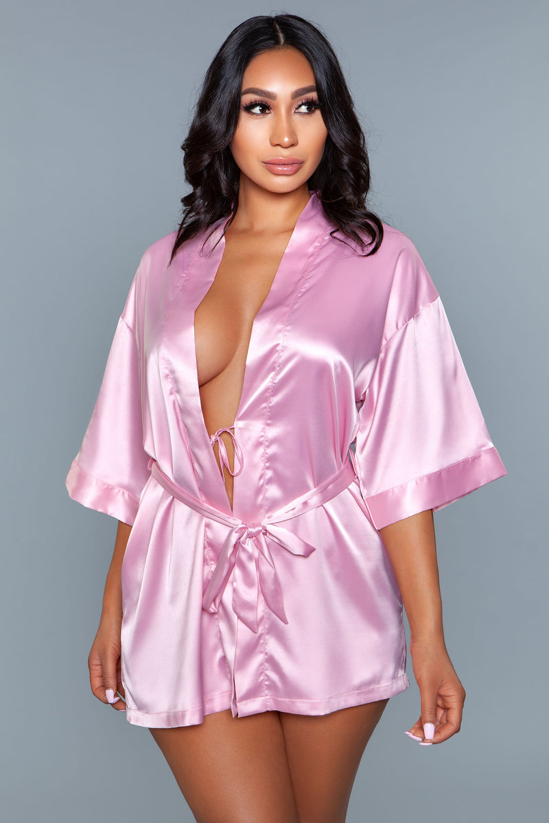 Model facing forward wearing light pink satin robe with side pockets. 3/4 sleeves and satin sash front tie