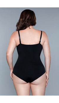 Model wearing seamless bodysuit body shaper with adjustable straps, and snap bottom closure in black facing back