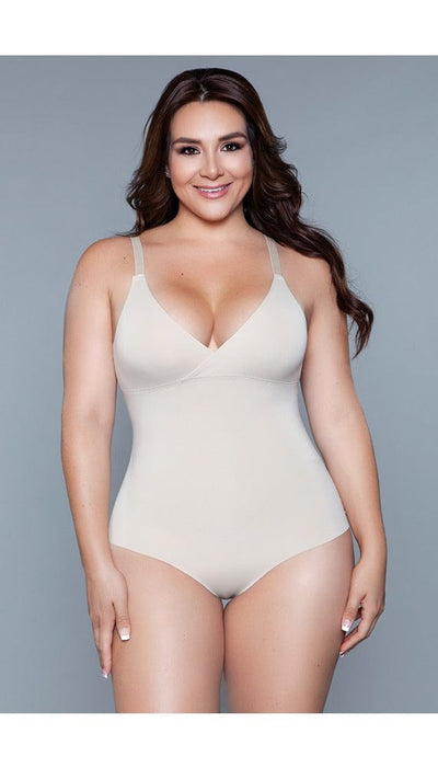 Model wearing seamless bodysuit body shaper with adjustable straps, and snap bottom closure in beige facing forward