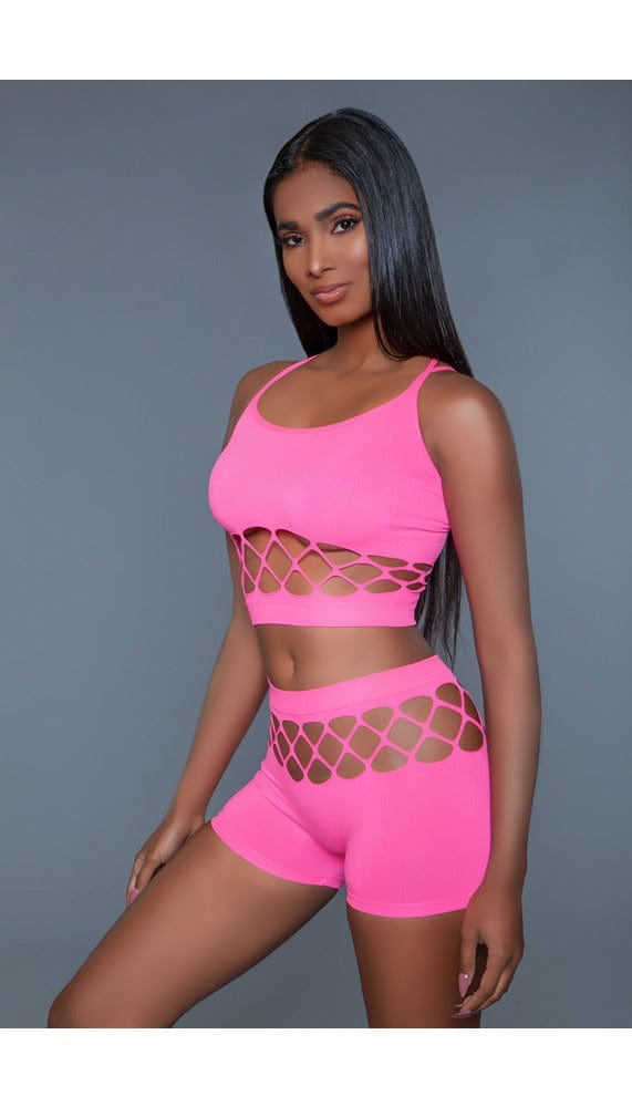 2 pc silk fishnet set that includes a tank crop top with crisscross cami straps and a pair of high-waisted booty shorts in pink facing front left