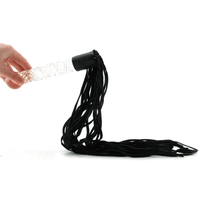 Image of a hand holding the glass dildo leather whip.
