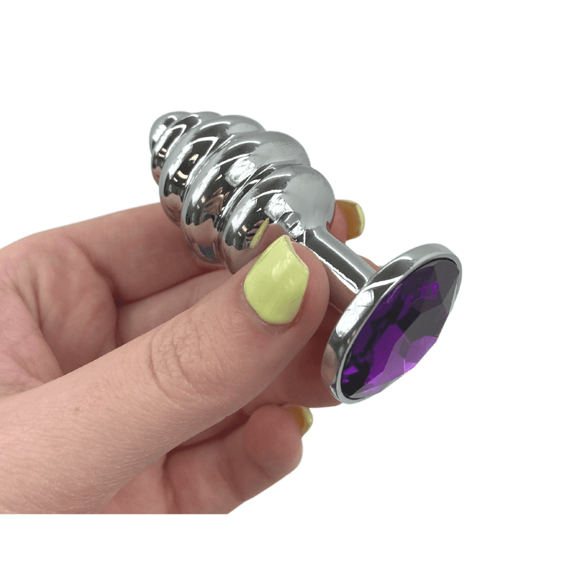 Image of the small butt plug with the purple jewel held in hand.