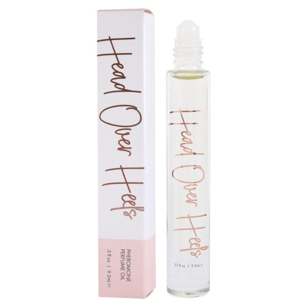 Image of the "Head Over Heels" scent. Product is standing next to the product packaging. The cap of the perfume is off.