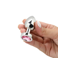 Image of the small weighted buss plug being held in hand, showing the pink jewel on the bottom.