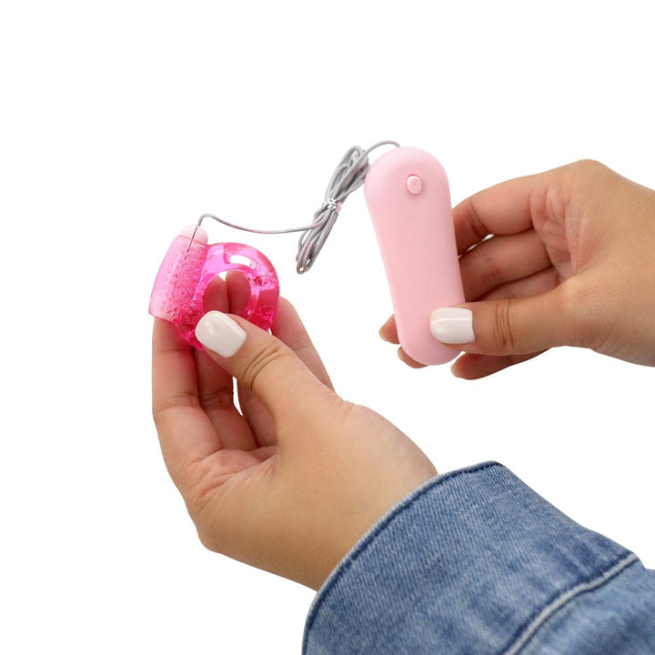 Vibrating jelly cock ring and remote held in hand.