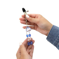 Jeweled nipple clamps held in hand.