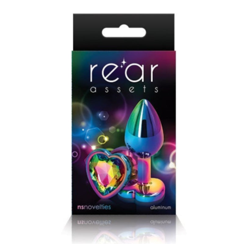 Image of the packaging for the Rainbow Heart Jeweled Metal Butt Plug in Rainbow color. Text reads rear assets, NS Novelties, aluminum.