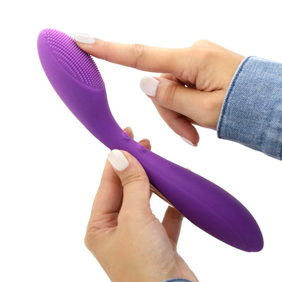 Image of the G-spot vibrator held in hand, turned slightly to the side, and with a finger on the nubby tip.