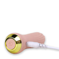 Image if the vibrator laying on its side, being charged with the charging cable plugged in (included).