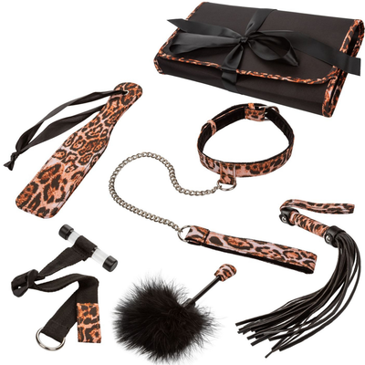 Image of the bondage kit out of its packaging. Here you can see all of the toys that this set includes! Pictures is a leopard collar and leash, a leopard paddle, tassels, a feather tickler, velcro cuffs, and the travel case!