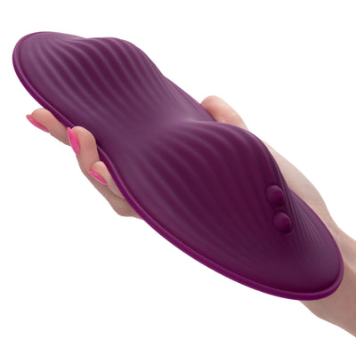 Image of a person holding the Lust Remote Control Dual Rider Hands-Free Sit On Vibrator. This textured silicone vibrator is lightweight but sturdy for easy to use hands-free riding.