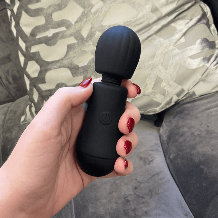 Lifestyle image of hand holding the wand massager.