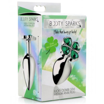 Image of the packaging for the Booty Sparks Lucky Clover Gem Metal Anal Plug. Text reads Booty Sparks green clover gem medium anal plug, make that booty get lucky, shake that shamrock, lucky clover gem medium anal plug.