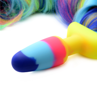 Close-up image of the butt plug. The plug itself is also rainbow; dark blue, light blue, pink, and yellow. This fun toy is perfect for spicing things up in the bedroom with your partner!